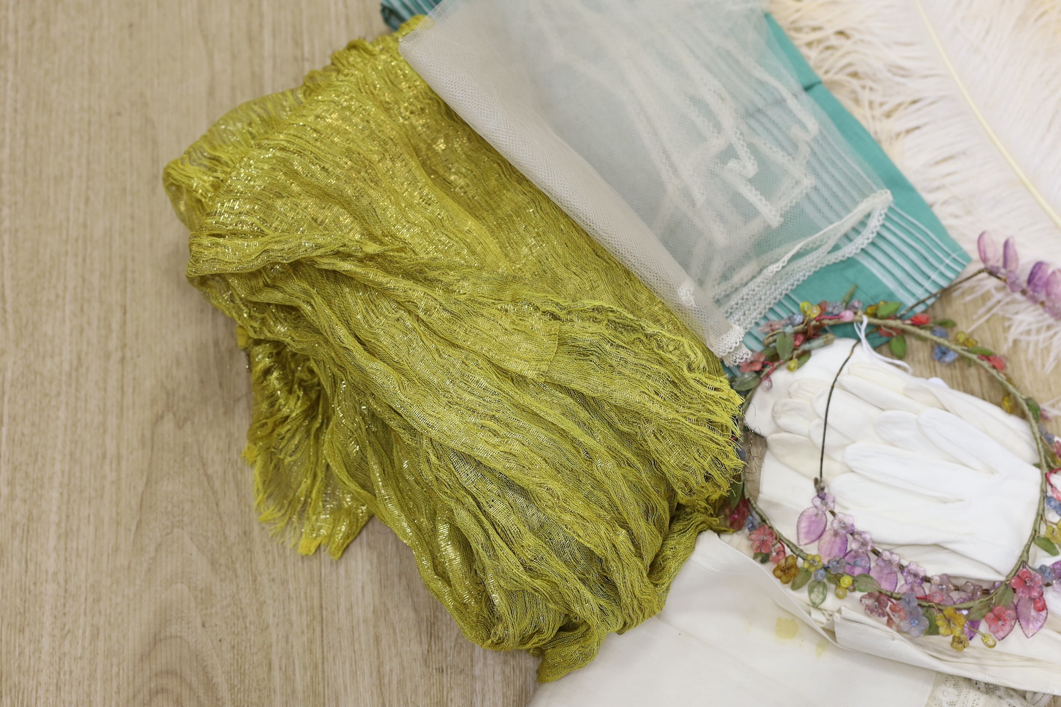 Two 1920's floral bead headdresses, a baby dress, gold fabric, two feathers and three prs of gloves